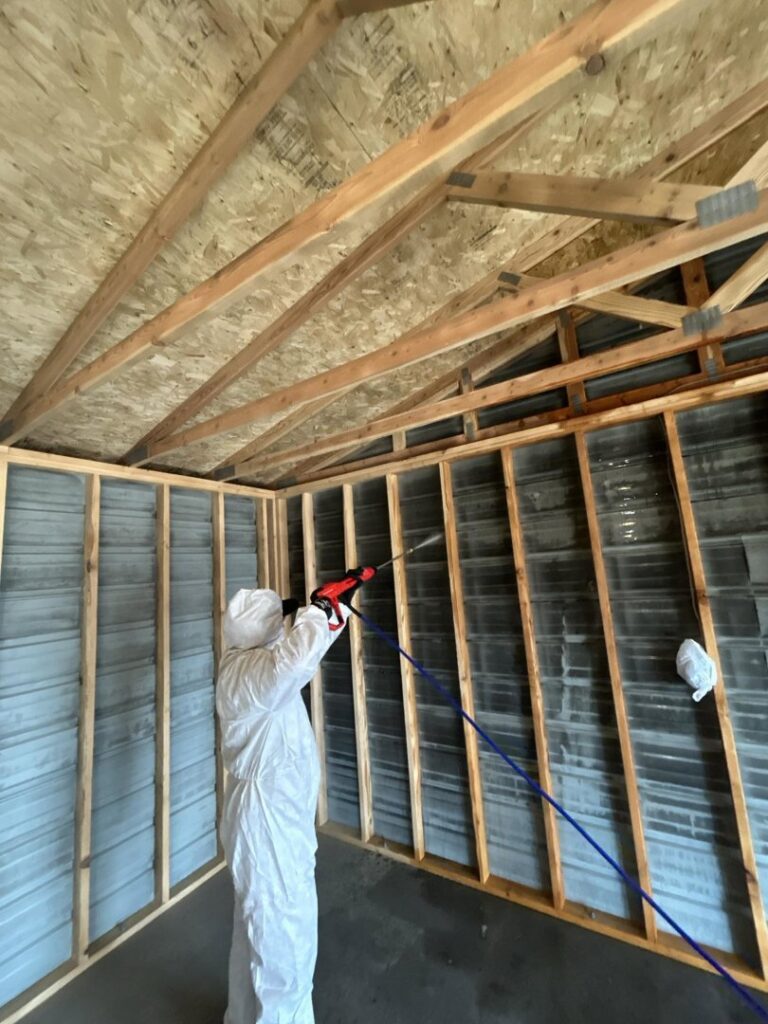 A technician in a hazmat suit spraying for mold remediation after water damage by 406 Disaster Response in Billings, MT.