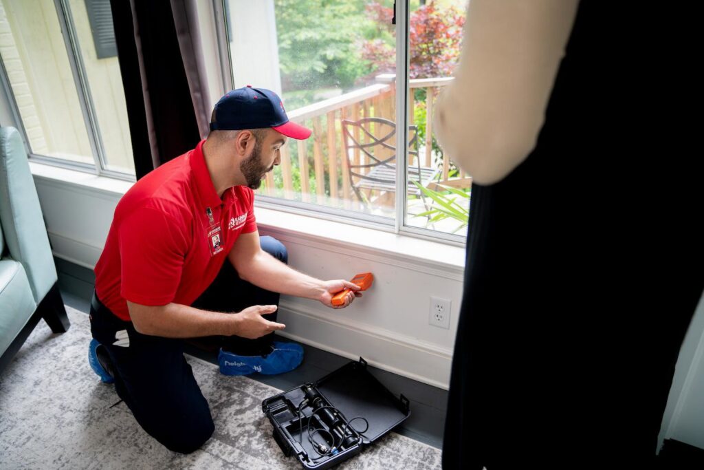 A Rainbow Restoration of Meridian technician using a moisture meter to detect hidden water damage in a wall in Meridian, ID.