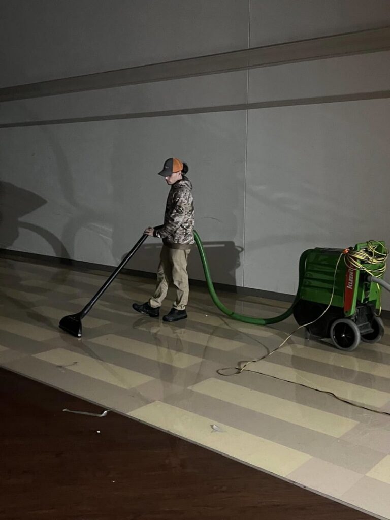 A SERVPRO of South Shreveport technician operating water extraction equipment on a floor in Shreveport, LA.