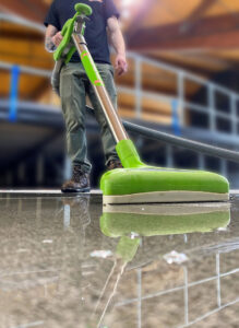 A Servpro of East Independence/Blue Springs technician performing water extraction on a wet floor with specialized equipment in Oak Grove, MO.