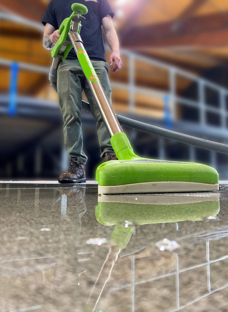 A Servpro of East Independence/Blue Springs technician performing water extraction on a wet floor with specialized equipment in Oak Grove, MO.