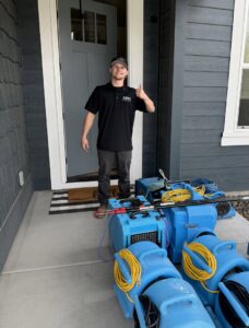 A technician with water damage restoration equipment ready at a client's home for APEX Restoration in Mililani, HI