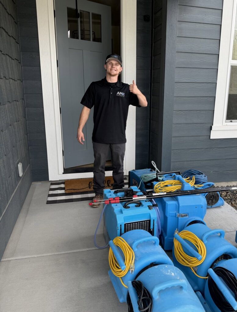 A technician with water damage restoration equipment ready at a client's home for APEX Restoration in Mililani, HI
