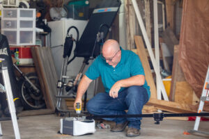 A technician working on a Chamberlain garage door opener unit on the floor for Bob McDonald Garage Door LLC in Columbus, NE.
