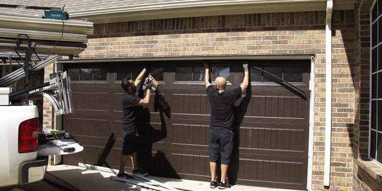 Two technicians installing a new garage door for Full Circle Overhead Door in Wilmington, DE.
