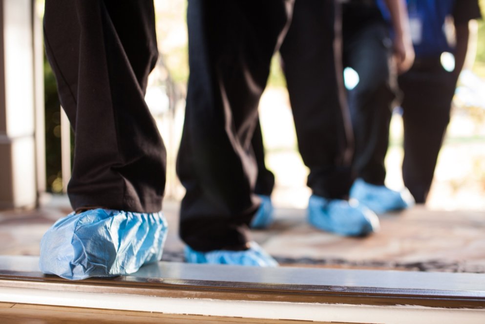 Technicians wearing protective shoe covers as they enter a client's home, demonstrating care from 1-800 WATER DAMAGE of Oklahoma City, OK.