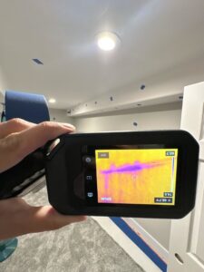 A thermal imaging camera detecting hidden moisture in a wall during a water damage assessment by Idaho Disaster Pros in Idaho Falls, ID.