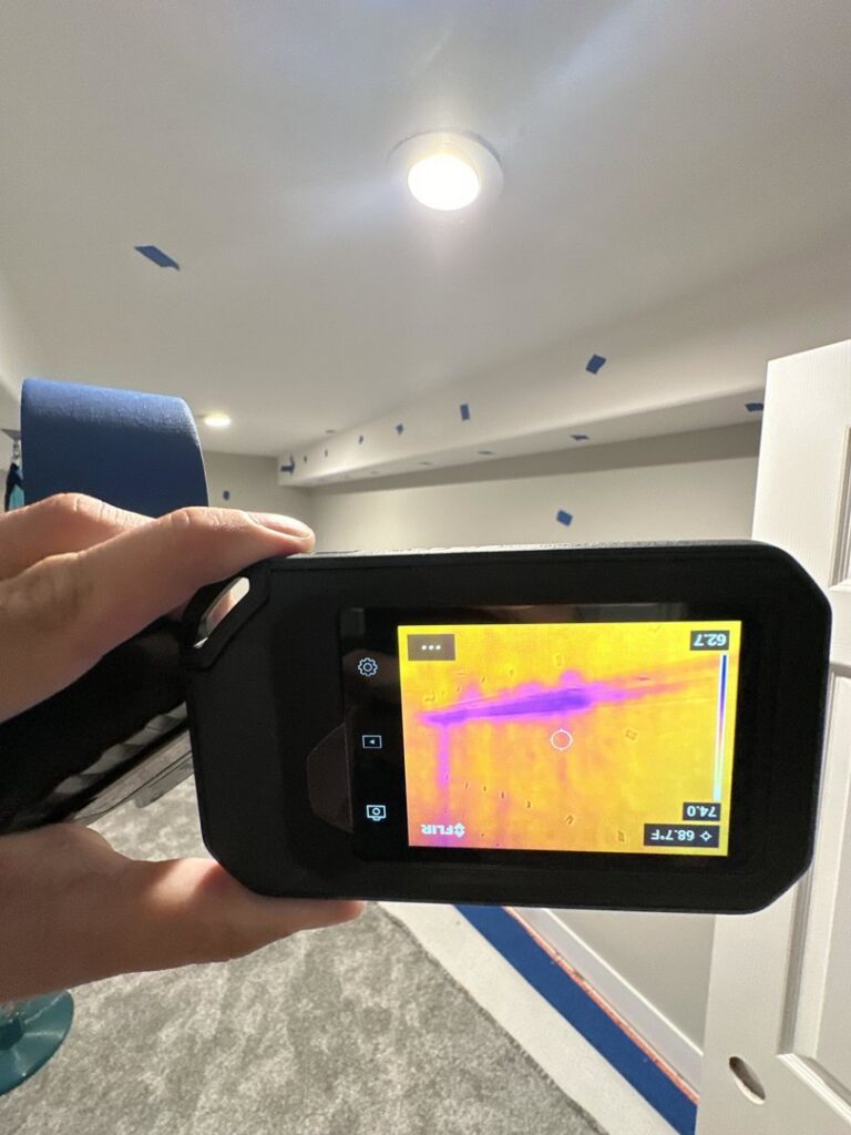 A thermal imaging camera detecting hidden moisture in a wall during a water damage assessment by Idaho Disaster Pros in Idaho Falls, ID.