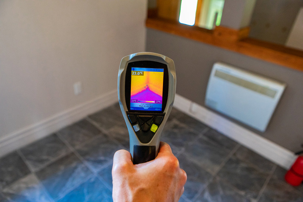 A thermal imaging camera being used to detect hidden moisture during a water damage assessment by Rescue One Restoration in Honolulu, HI.