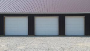 Three white commercial garage doors installed on a building by Cedar Valley Garage Doors in Waterloo, IA