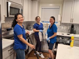 Three friendly house cleaners from Absolute Luxury, LLC Residential & Commercial Cleaning smile in a sparkling clean kitchen in Antioch, TN.