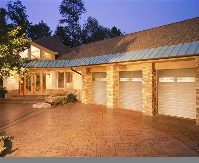 A large house with three light-colored garage doors with windows installed by The Door Man - Garage Doors & Openers in Reno, NV