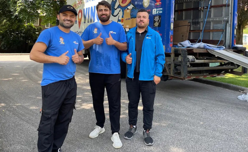 Three professional movers giving thumbs up next to a Let's Get Moving truck with its ramp down in Saint Petersburg, FL.