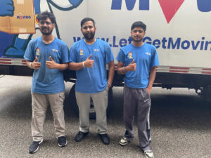 Three friendly movers giving thumbs up in front of a Let's Get Moving truck in Saint Petersburg, FL.