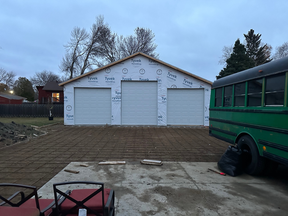Three new white sectional garage doors installed on a new construction garage by JTL Garage Doors in Fargo, ND.