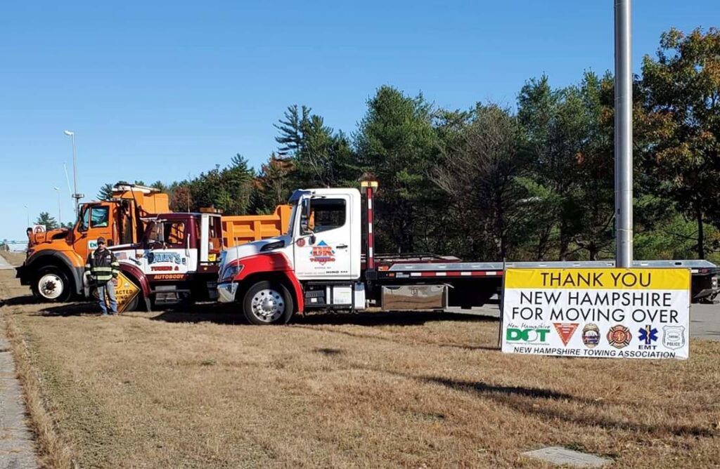 Three tow trucks from Bailey's Towing and Auto Body, LLC parked with a 'Move Over' safety sign in Merrimack, NH.