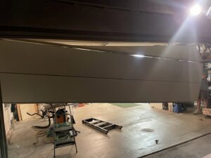 Three white garage doors installed in a new construction garage by Summit Garage Door in Overland Park, KS.
