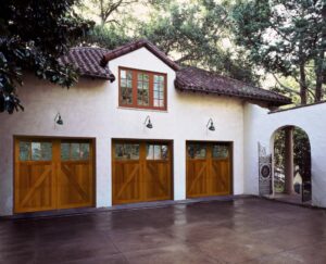 A beautiful home with three wooden carriage-style garage doors, installed by Overhead Door Co of Missoula in Missoula, MT.
