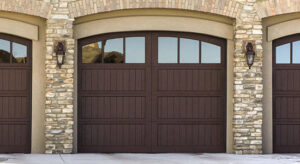 Three wooden-style garage doors with windows on a modern home by Custom Overhead Doors of Southern New Mexico in Alamogordo, NM.