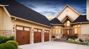 Three newly installed wooden-style garage doors on a large residential house by Up & Down Garage Doors in Bridgeport, CT.