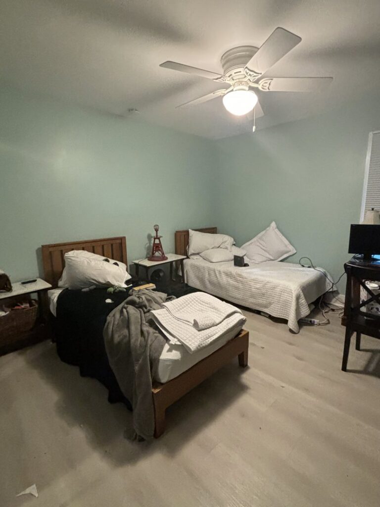 A tidy and well-arranged bedroom with two beds, reflecting the quality house cleaning provided by Cleaning Sisters LLC in Richmond, VA.