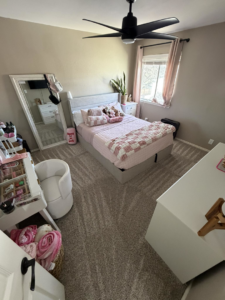 A tidy bedroom with a neatly made bed and freshly vacuumed carpet, cleaned by Lupita's cleaning services in San Antonio, TX.