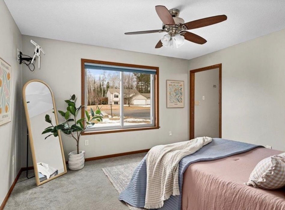 A tidy bedroom featuring a large window and clean carpet, reflecting professional house cleaning from Tidy Details in Duluth, MN.