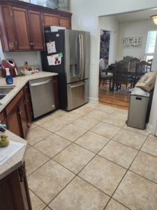 A tidy kitchen with tiled floors, wooden cabinets, and stainless steel appliances, leading to a clean dining area by S&M Cleaning Services 5 LLC in Cocoa, FL.