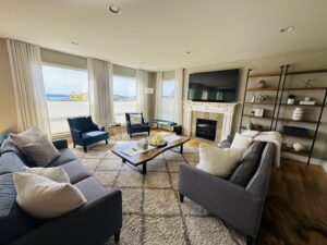 A tidy and inviting living room with comfortable sofas, a large area rug, and a fireplace, professionally cleaned by Quesada's cleaning services llc in Seattle, WA.
