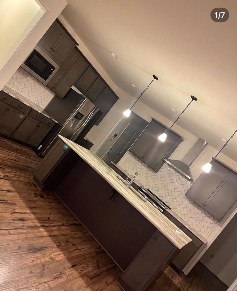 A tidy modern kitchen with dark cabinets and a large island, professionally cleaned by Per Your Request Richmond in Glen Allen, VA.
