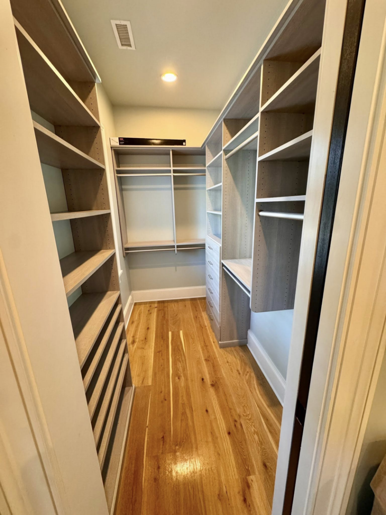 A tidy walk-in closet with clean shelves and a polished hardwood floor, cleaned by Affordable Cleaning in North Charleston, SC.