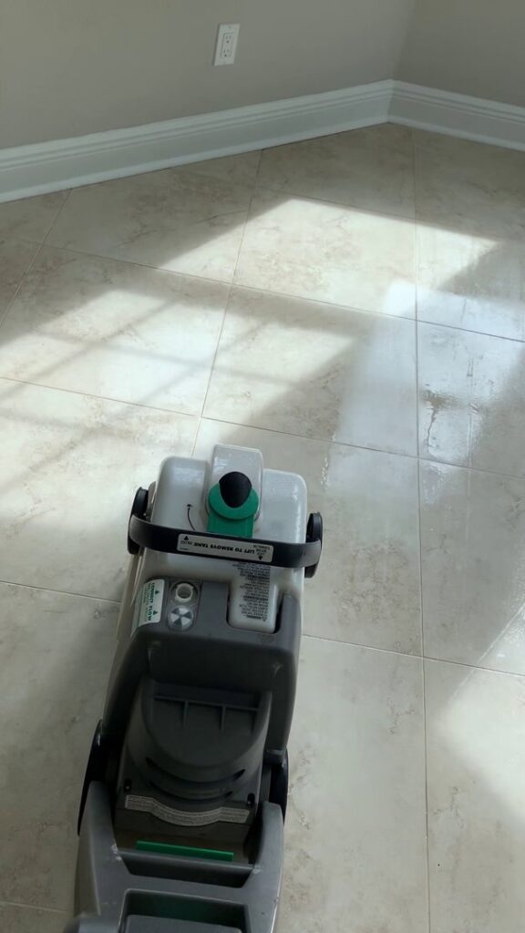 A floor cleaning machine meticulously cleaning a tiled floor in a home by Cleaning Partners in Tampa, FL