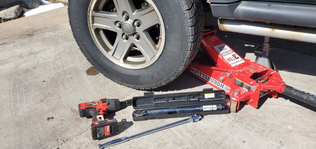A car jack and tire change tools on the ground, ready for a tire service by Liberty Auto Rescue in Colorado Springs, CO.