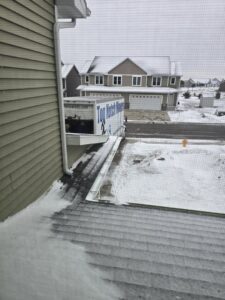 A Top Notch Movers truck parked in a snowy residential area in Madison, WI, ready for a winter move.