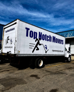 A Top Notch Movers truck parked in a lot under a bright blue sky in Madison, WI.