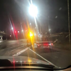 A tow truck with flashing lights on the road at night for Bobby's TCB Towing in Detroit, MI