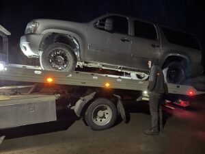 A Solid Choice Towing flatbed truck loading a large SUV during a nighttime recovery operation in Wasilla, AK.