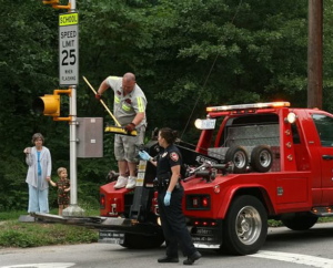 A tow truck operator and another person at an incident scene with a red tow truck in Roseville, CA