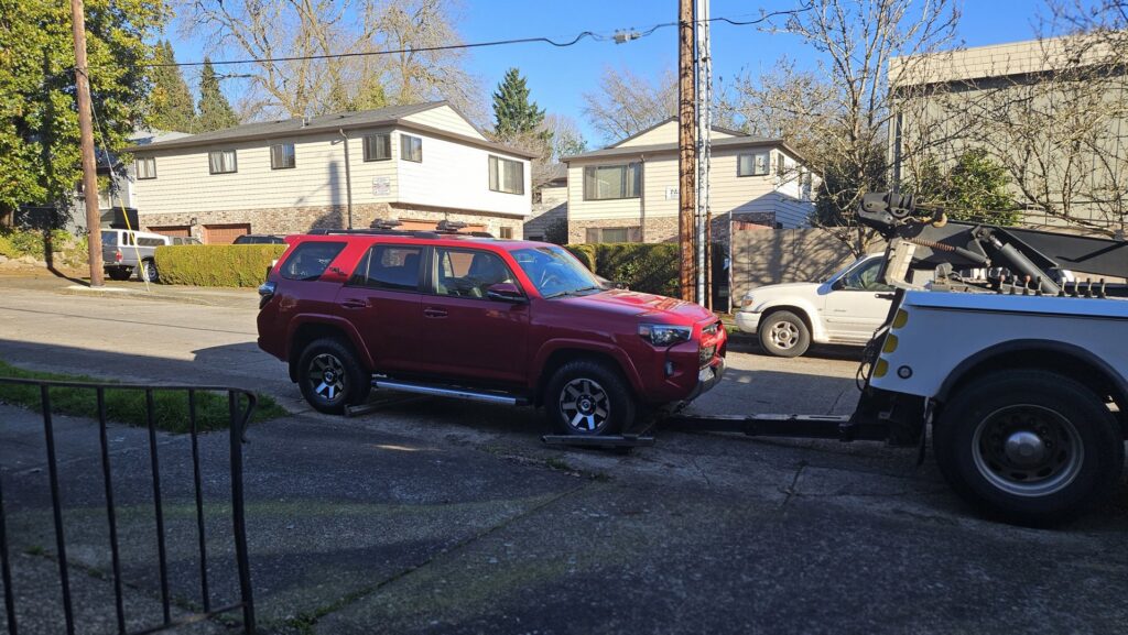 A Speed's Towing operator giving a thumbs up while towing a box truck in Vancouver, WA.
