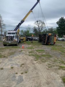 A tow truck from Bailey's Towing and Auto Body, LLC recovering an overturned school bus in Merrimack, NH.