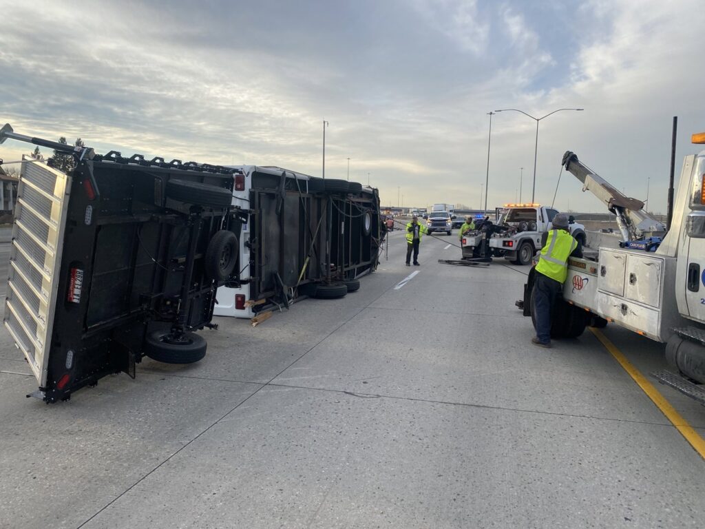 A tow truck from Automotive Technical Services recovering an overturned trailer on a highway in Boise, ID.