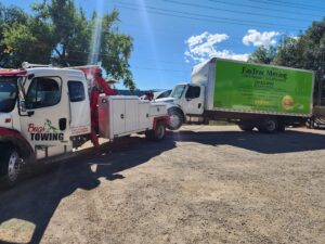 A tow truck from Towing Colorado providing service to a green box truck in Colorado Springs, CO.