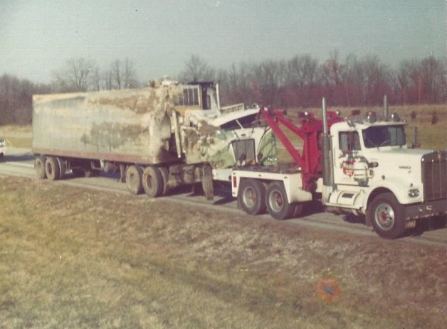 An old photo of a Bevis Towing truck towing a damaged semi-trailer in Cincinnati, OH.