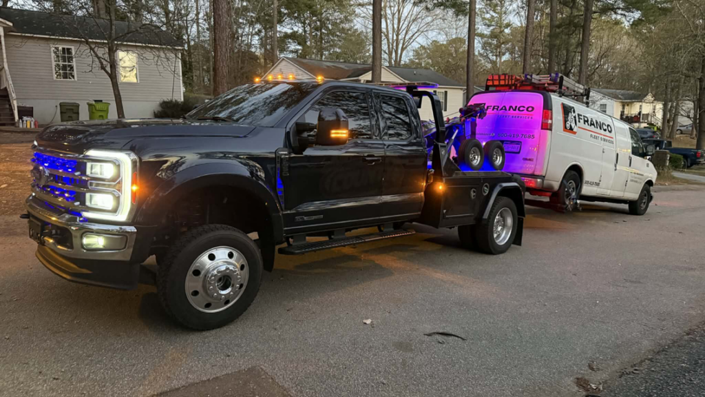 Tow truck towing a white van with flashing lights at night for County Towing & Recovery LLC in West Columbia, SC.