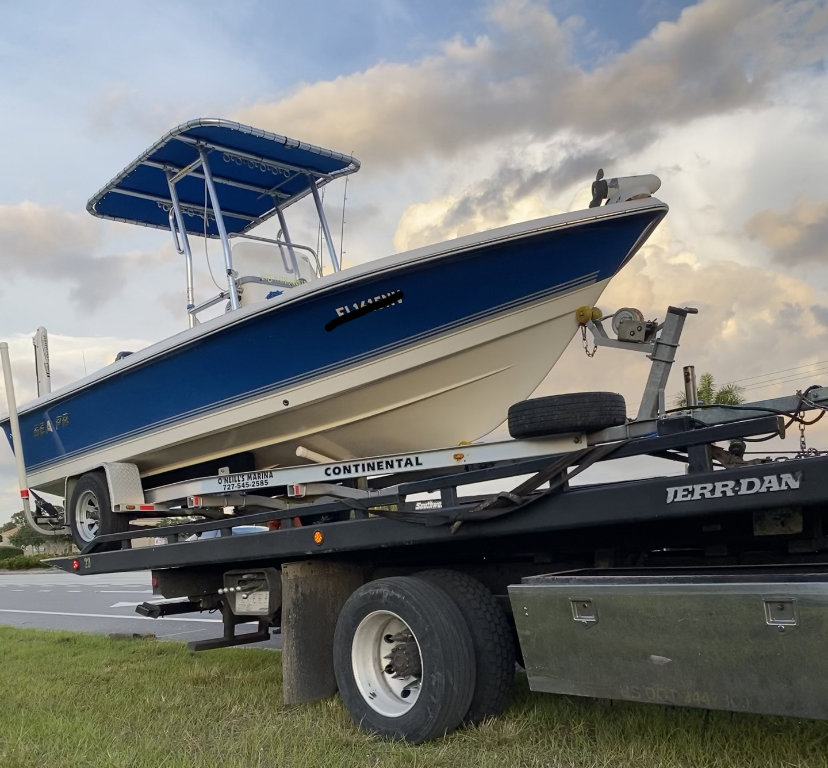 A tow truck from Always Ready Towing transporting a boat on a trailer in North Fort Myers, FL.