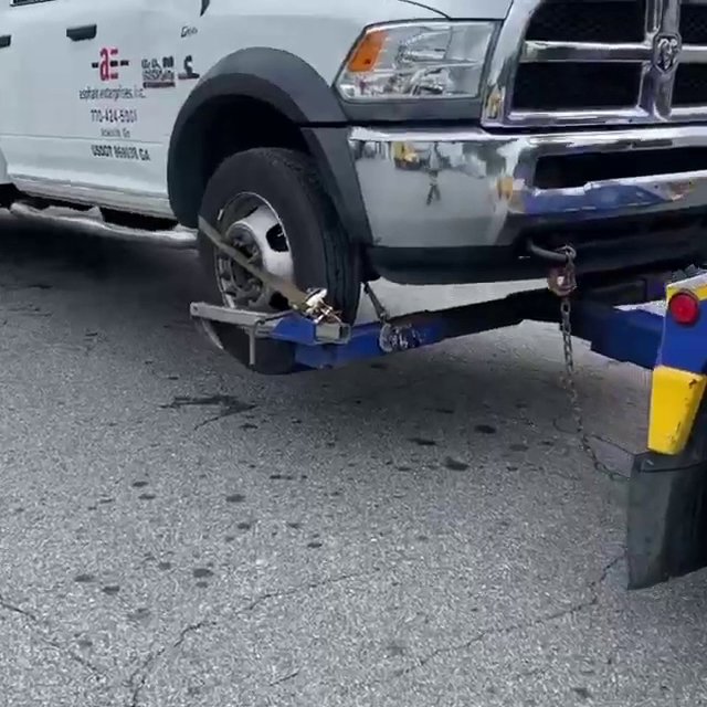 A close-up view of a tow truck's wheel lift mechanism in operation by Andre's Towing Services, LLC in Marietta, GA.