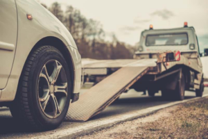 A tow truck with its ramp extended, ready to load a white car, demonstrating towing services from A1 Towing Las Vegas Henderson, NV.