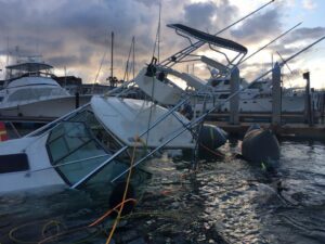 TowBoatUS San Diego assisting a sinking boat with flotation devices in a marina in San Diego, CA.