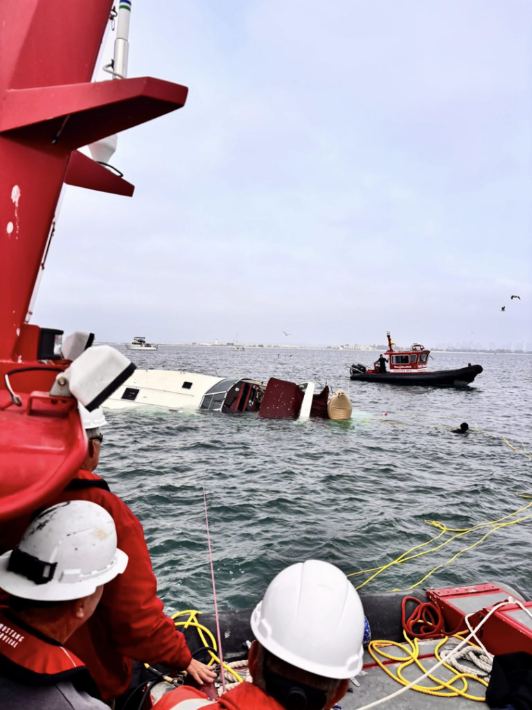 TowBoatUS San Diego crew assisting a partially submerged boat during a rescue operation in San Diego, CA.