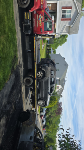 Craig's Towing & Recovery flatbed tow truck loading a burned SUV in New Castle, DE.